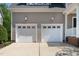 Close up of two car garage featuring white carriage doors and concrete driveway at 5605 Cary Glen Blvd, Cary, NC 27519