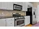 Kitchen featuring stainless steel appliances, white cabinetry, and stone countertops at 5605 Cary Glen Blvd, Cary, NC 27519