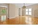 Bright living room featuring hardwood floors, large windows, and an elegant chandelier at 5605 Cary Glen Blvd, Cary, NC 27519