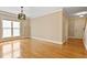 Open living room with hardwood floors, large window, and elegant light fixture at 5605 Cary Glen Blvd, Cary, NC 27519