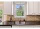 Kitchen sink area with a window, quartz countertops, and neutral tile backsplash at 5605 Cary Glen Blvd, Cary, NC 27519