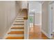Open staircase with hardwood steps and access to multiple floors and rooms at 5605 Cary Glen Blvd, Cary, NC 27519