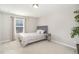 Cozy bedroom with neutral walls, a plush carpet, and a comfortable bed next to a bedside table at 717 Silo Park Dr, Wake Forest, NC 27587