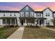 Inviting townhome exterior features a landscaped yard and charming front porch at sunset at 717 Silo Park Dr, Wake Forest, NC 27587