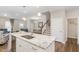Open kitchen with island seating and stainless sink overlooking the living area and stairs at 717 Silo Park Dr, Wake Forest, NC 27587
