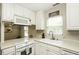 Well-maintained kitchen features white cabinets, modern appliances, and a bright window over the sink at 732 Westview Ct, Nashville, NC 27856