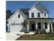 Charming two-story home with white siding, a covered porch, attached garage, and manicured lawn at 755 Bachelor Gulch Way, Apex, NC 27523