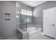 Contemporary bathroom featuring a glass-enclosed tub/shower and neutral gray tiling at 756 Bachelor Gulch Way, Apex, NC 27523