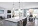 Living area showcasing the fireplace, television, kitchen island and access to dining area at 756 Bachelor Gulch Way, Apex, NC 27523