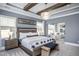 This main bedroom features wooden ceiling beams, a stylish light fixture, and elegant decor at 756 Bachelor Gulch Way, Apex, NC 27523