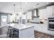 Bright kitchen boasts a large quartz island, pendant lighting, stainless steel appliances, and modern white cabinets at 760 Bachelor Gulch Way, Apex, NC 27523