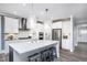 Elegant kitchen featuring quartz island, pendant lighting, stainless appliances, and white cabinetry at 760 Bachelor Gulch Way, Apex, NC 27523