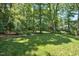 Spacious backyard featuring lush green grass, mature trees, and manicured landscaping at 9 Kimberly Dr, Durham, NC 27707