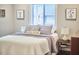 Bright bedroom featuring neutral walls, soft bedding, and natural light from a window at 918 Orient St, Durham, NC 27701