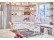 Bright kitchen featuring stainless steel appliances, white cabinets and floating wood shelves at 918 Orient St, Durham, NC 27701