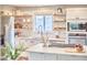 Bright kitchen with white cabinets, stainless steel appliances, open wood shelving and eat in bar at 918 Orient St, Durham, NC 27701