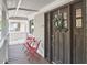 Inviting front porch with outdoor seating, views of the neighborhood, and beautiful dark wood door at 918 Orient St, Durham, NC 27701