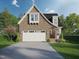 Charming brick home showcasing an attached two-car garage and beautifully landscaped front yard at Lot 9 Powell Dr, Raleigh, NC 27606