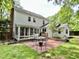 A backyard featuring a red brick patio with a dining set, a screened in porch and mature trees at 1002 Springmill Ct, Apex, NC 27502