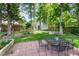 Backyard with a patio, dining set, shed in the background, and lush green trees at 1002 Springmill Ct, Apex, NC 27502