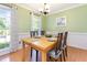 Inviting dining room featuring hardwood floors, modern light fixture, and neutral color palette at 1002 Springmill Ct, Apex, NC 27502