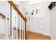 Foyer with hardwood floors, a decorative glass front door, a staircase with wooden handrail, and a white coat rack at 1002 Springmill Ct, Apex, NC 27502