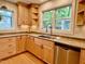 Kitchen area with stainless steel appliances, wooden cabinets, stone counter tops, hardwood floors, and large windows at 1002 Springmill Ct, Apex, NC 27502