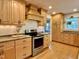 Kitchen with wooden cabinets, stainless steel appliances, granite countertops, hardwood floors, and a range hood at 1002 Springmill Ct, Apex, NC 27502