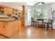 Open kitchen with wooden cabinetry, a kitchen island, stainless steel appliances, hardwood floors, and a breakfast nook at 1002 Springmill Ct, Apex, NC 27502