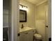 A clean bathroom featuring a vanity with a mirror, white wainscotting, and modern fixtures at 101 Pine St, Dunn, NC 28334