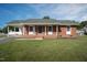 Charming brick home featuring a covered porch with a well-manicured lawn at 101 Pine St, Dunn, NC 28334