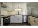 A modern kitchen boasting white cabinets, a farmhouse sink, and stainless steel appliances at 101 Pine St, Dunn, NC 28334