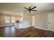 An open living space featuring wood floors, a ceiling fan, and natural light from the kitchen at 101 Pine St, Dunn, NC 28334