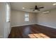 Bright living room with laminate flooring, a ceiling fan, a window, and a white door at 101 Pine St, Dunn, NC 28334