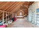 Large unfinished attic space features open rafters, plywood flooring and a window offering natural light at 103 Woodland Ridge Ct, Cary, NC 27519