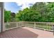 Inviting outdoor wooden deck with white railing and view of green space at 103 Woodland Ridge Ct, Cary, NC 27519