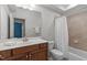 Well-lit bathroom featuring a vanity with solid surface countertop, tiled shower and tub combo and white fixtures at 103 Woodland Ridge Ct, Cary, NC 27519