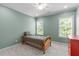 Charming bedroom featuring a twin bed, ceiling fan, and natural light from two windows at 103 Woodland Ridge Ct, Cary, NC 27519