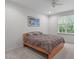 Bright bedroom with a ceiling fan, window and a simple bed frame with neutral bedding and artwork on the wall at 103 Woodland Ridge Ct, Cary, NC 27519