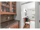 Butler's pantry boasts a built-in cabinet, stone countertop, backsplash, and easy access to the dining room at 103 Woodland Ridge Ct, Cary, NC 27519