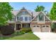 Stunning exterior of the home with a manicured lawn, beautiful landscaping, and a three-car garage at 103 Woodland Ridge Ct, Cary, NC 27519