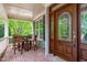 Covered front porch with wood chairs and a table showcases the home's lovely front door at 103 Woodland Ridge Ct, Cary, NC 27519