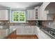 Bright kitchen features stainless steel appliances, granite countertops, and wood floors at 103 Woodland Ridge Ct, Cary, NC 27519