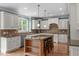 Gourmet kitchen with white cabinetry, granite countertops, a center island, and stainless steel appliances at 103 Woodland Ridge Ct, Cary, NC 27519