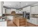 Spacious kitchen featuring granite countertops, a center island, stainless steel appliances, and custom cabinetry at 103 Woodland Ridge Ct, Cary, NC 27519