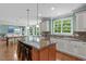 Well-lit kitchen features a center island with bar seating, granite countertops, and stainless steel appliances at 103 Woodland Ridge Ct, Cary, NC 27519