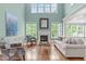 Spacious living room with soaring ceilings, a fireplace, large windows, and hardwood flooring at 103 Woodland Ridge Ct, Cary, NC 27519