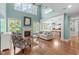 Bright living room with high ceilings, large windows, fireplace, and open layout to the kitchen at 103 Woodland Ridge Ct, Cary, NC 27519