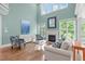 Bright living room showcasing a fireplace, large windows, hardwood flooring, and comfortable seating at 103 Woodland Ridge Ct, Cary, NC 27519