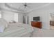 Large main bedroom featuring a tray ceiling, TV, and sitting area for ultimate relaxation at 103 Woodland Ridge Ct, Cary, NC 27519